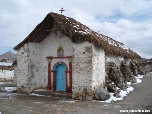 Parinacota Church, Parinacota-Arica, Chile. Old mud church with bright blue door and decorative arch at the entrance.